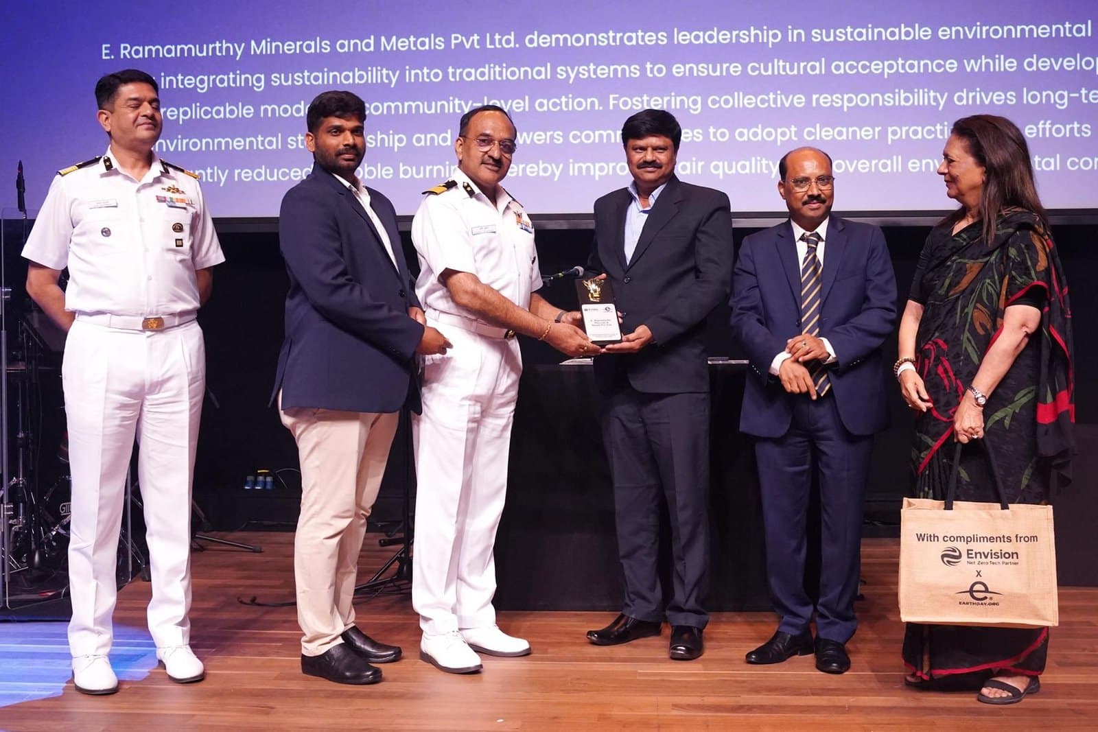 ERM Group receiving an EarthDay.org trophy on stage for sustainable environmental practices