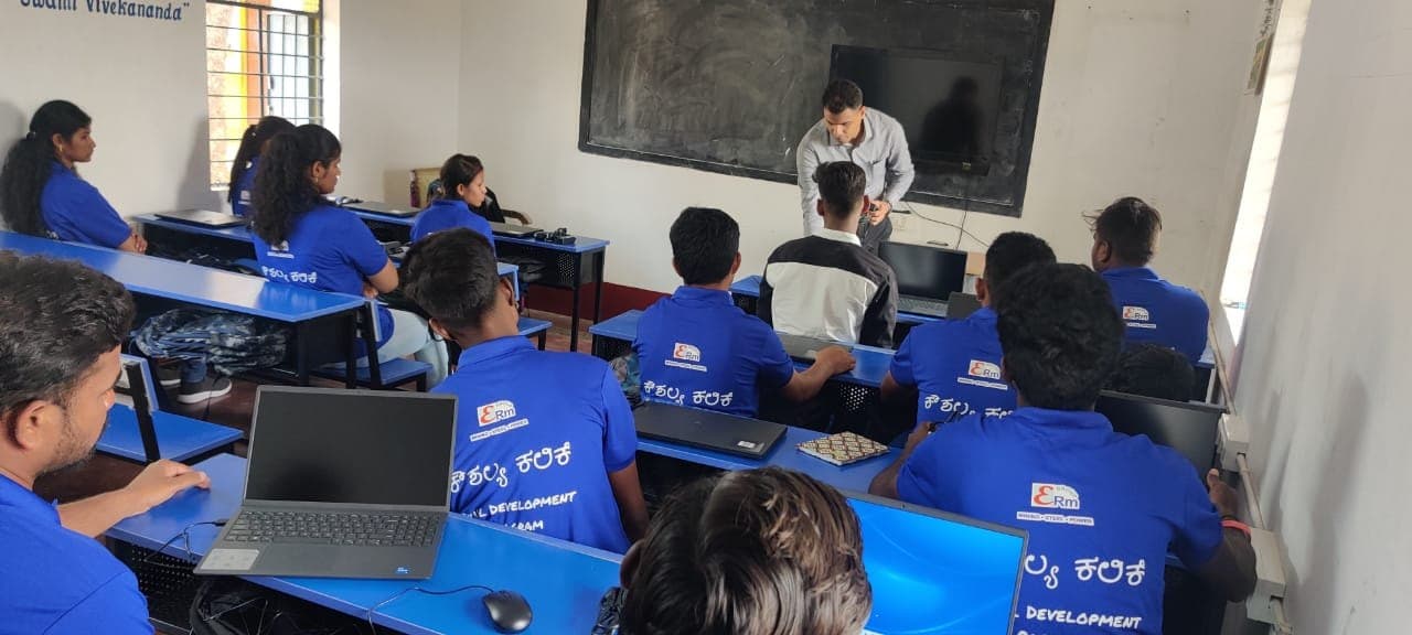 Instructor assisting a trainee at a computer during a skill development class